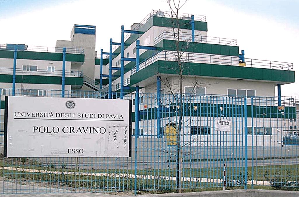 Pavia Medicine in English campus building picture, with a blue fence outside.